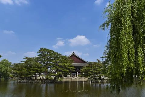 A pond with a red building in the background Stock Photos