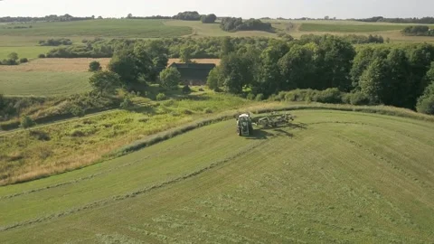 Pond5 Tractor and Rotary Rake Rowing Hay 22 01 Stock Footage 205480214