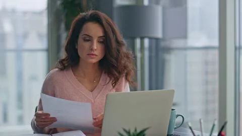 Pondering lady holding documents checking information at home office closeup 스톡 사진