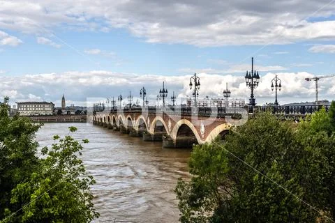 Pont De Pierre over Garonne River against cloudy sky in city Stock Photos