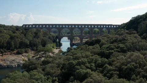 Pont du Gard aerial traveling over trees river Gardon and passing through arches Stock Footage