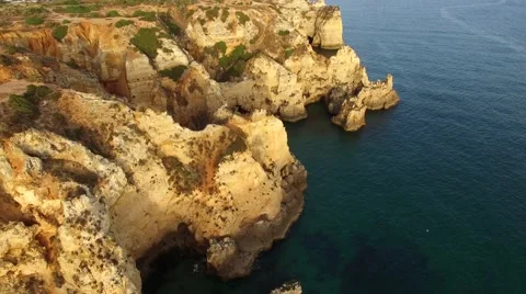 Ponta da Piedade lighthouse on cliff near ocean at sunset, Lagos, aerial view Stock Footage 64967445