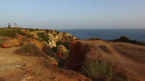 Ponta da Piedade lighthouse on cliff near ocean at sunset, Lagos, aerial view Stock Footage 64967683