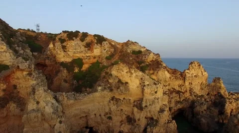 Ponta da Piedade lighthouse on cliff near ocean at sunset, Lagos, aerial view Stock Footage 64968114