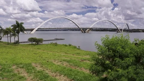 Ponte JK arches span Lake Paranoa above restored Cerrado vegetation in Vídeos de archivo 345080174