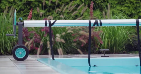 The pool in the backyard of the house is covered with a sheet for energy saving Stock Footage 249476299
