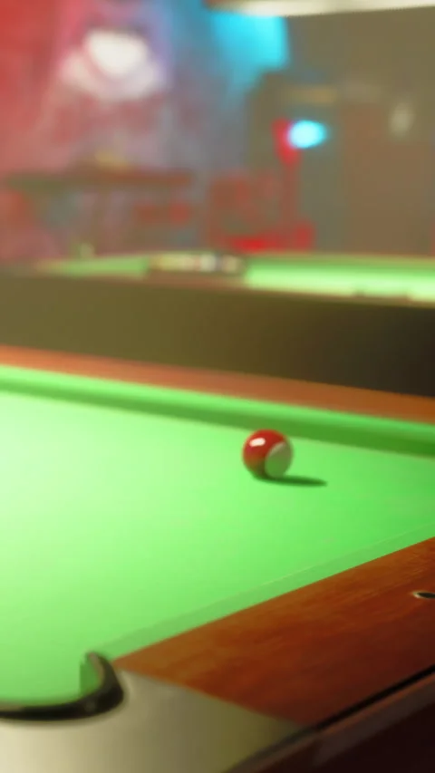Pool ball rolls on a green felt table in a dimly lit game room Stock Footage 339507700
