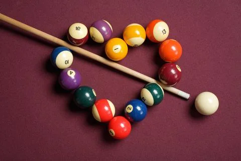 Pool balls arranced in heart shape with cue stick bisecting Stock Photos