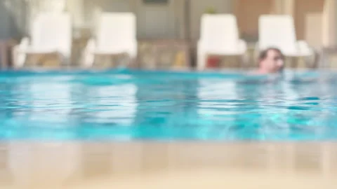 In the pool on a bright sunny day, a young man swims in the pool Stock Footage 241510962