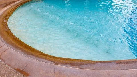 A pool with a brown edge and a blue water Stock Photos