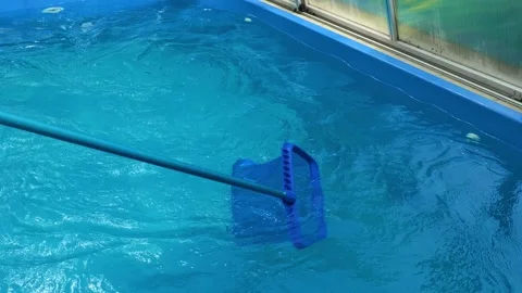 Pool care.Pool skimmer net cleaning clear blue swimming pool water Stock Footage 339608963