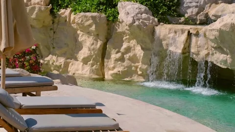 Pool chairs egypt, a small artificial waterfall on site Stock Footage 240200505