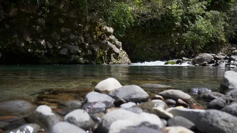Pool in clear freshwater stream flowing over boulders in forest Stock Footage 99141799