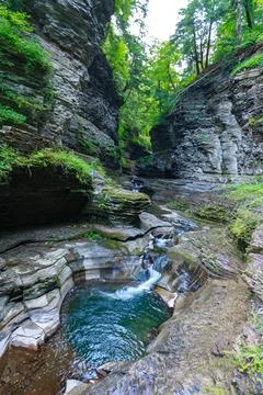 A pool with clear water formed by a cascade of waterfalls of a small river .. Stock Photos