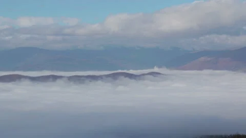 A pool of clouds subtly moving below the mountains, Full HD 1080 Cinematic Stock Footage 146914945