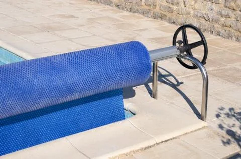 Pool cover rolled up on a roller Stock Photos