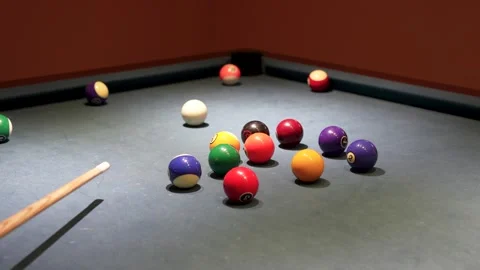 Pool cue hitting cue ball to strike numbered nine ball on billiard table cl.. Stock Footage 340036224
