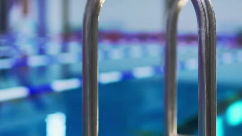 Pool equipped with shining steel ladders installed around perimeter Stock Footage 291333791