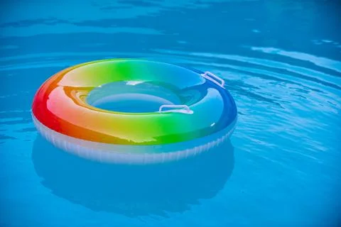 Pool float, ring floating in a refreshing blue swimming pool. Summer background. Stock Photos