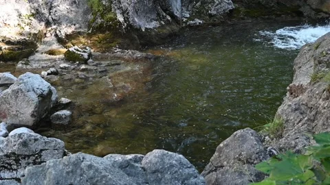 A pool in front of a waterfall in the mountains (slow motion) 스톡 동영상 219385608