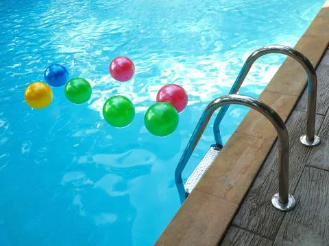 Pool fun concept with an inflatable plastic beach ball floating in cool cryst Stock Photos