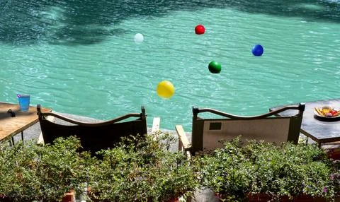 Pool fun concept with an inflatable plastic beach ball floating in cool cry.. Photos