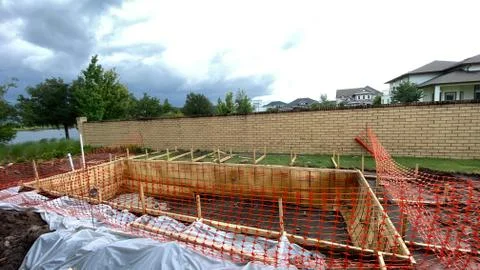 A pool that has been framed behind a house Stock Photos