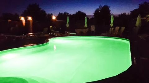 The pool is illuminated with green light at night. Stock Photos