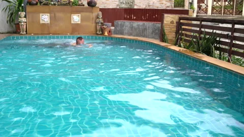 In the pool with a jacuzzi man swims Stock Footage 91830854