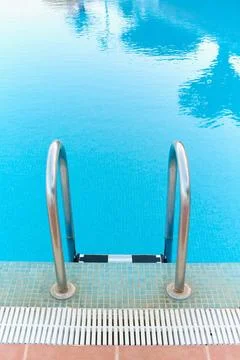 Pool ladder somewhat deteriorated by pool products in the foreground Stock Photos