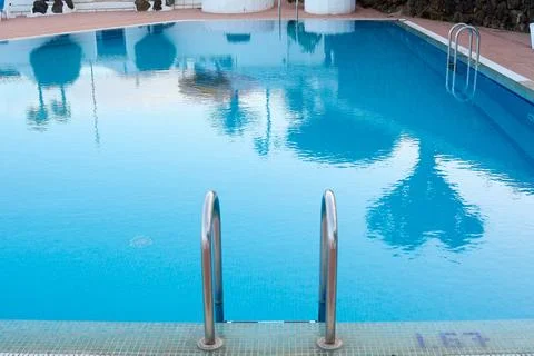 Pool ladder somewhat deteriorated by pool products in the foreground Stock Photos