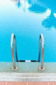Pool ladder somewhat deteriorated by pool products in the foreground Stock Photos