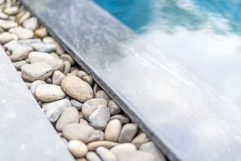 Pool with pebble border framed with stone. Stock Photos