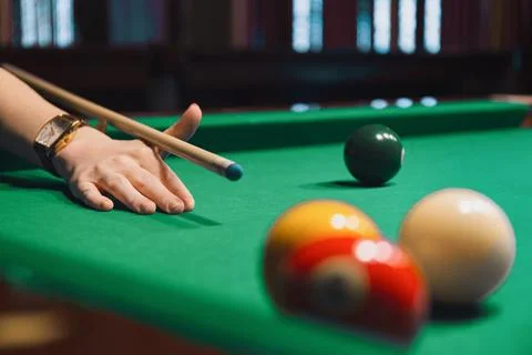 Pool Player Lining Up Shot with Cue Stick Stock Photos