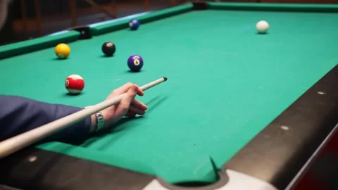 Pool player misses a precise shot, cue stick over green felt as scattered balls Stock Footage 328339049