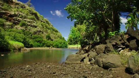 Pool at rivers end, rocks, hill with blue sky and fast moving clouds. Video stock 80512946
