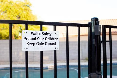 Pool safety gate with sign emphasizing water safety Stock Photos