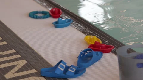 Pool side flip flops and toys close up. Swim classes for babies. Stock Footage 237645997