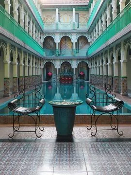 A pool surrounded by chairs and a table in a leisure area. 스톡 사진
