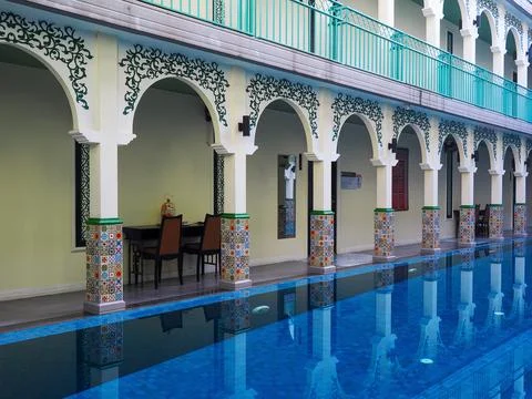 A pool surrounded by chairs and a table in a leisure area. Stock-Fotos