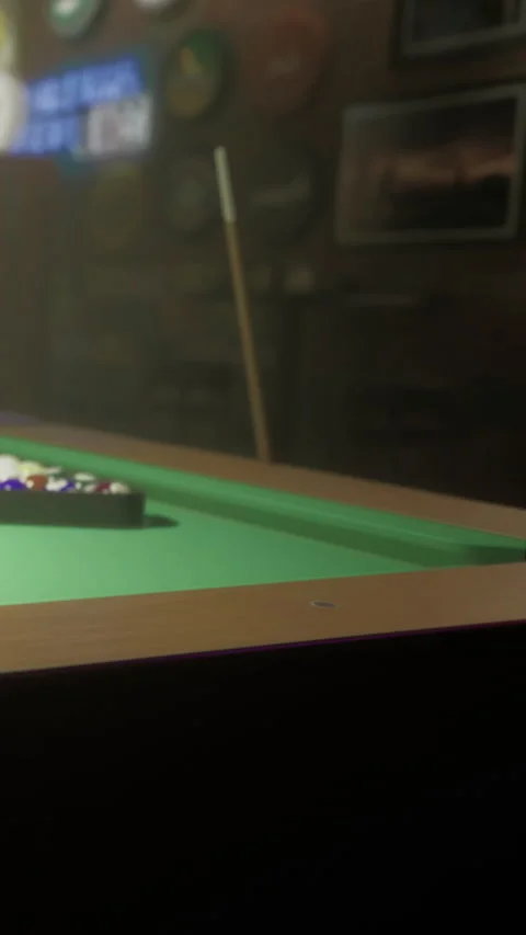 Pool table with balls arranged for a game in a dimly lit room Stock Footage 331750943