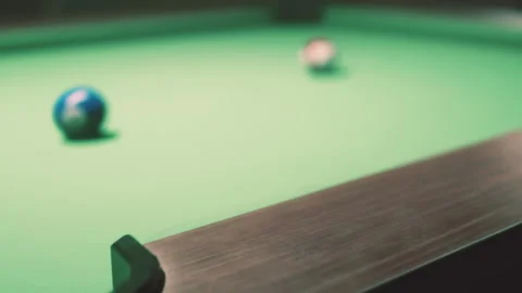 Pool table with balls in a dimly lit game room during evening hours Stock Footage 344883225