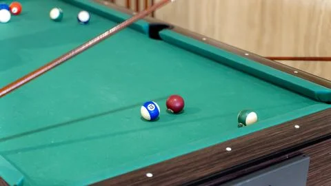 Pool Table with Billiard Balls and Cue in Indoor Game Room Stock Photos
