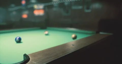 Pool table with colorful balls in dimly lit bar setting at night Stock Illustration