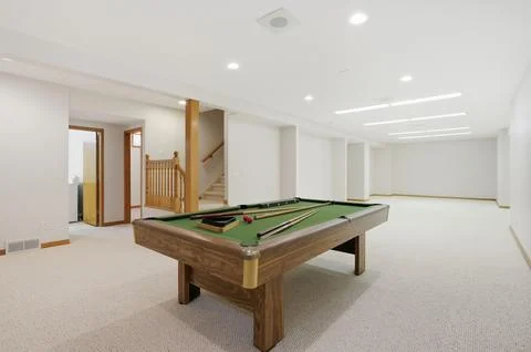 Pool table sits in a large, empty room Stock Photos