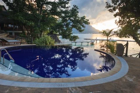 Pool at tropical beach at sunset 스톡 사진