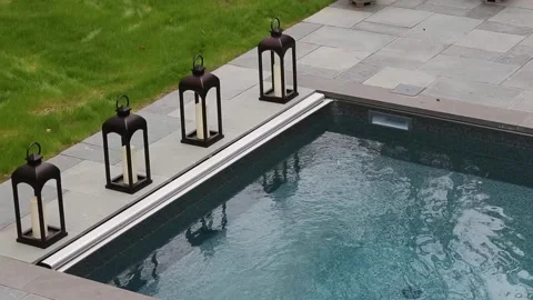 Pool-water bubbling and rippling in an outdoor swimming pool with candle holder  Stock Footage 251880307