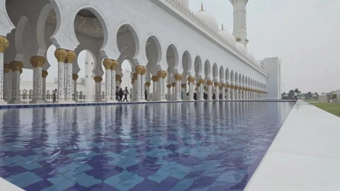 Pool water reflects columns of arcade courtyard, Sheikh Zayed Grand Mosque, Abu Stock Footage 327553632