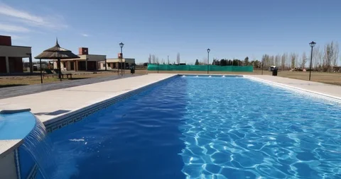 Pool with waterfall. Camera over water traveling with circular movement Stockbeeldmateriaal 98116612