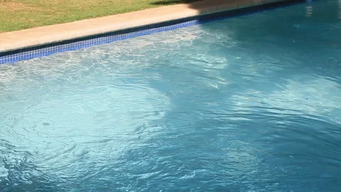 Pool Waves Rippling in the Bright Sun, grass in the background Stock Footage 185092485